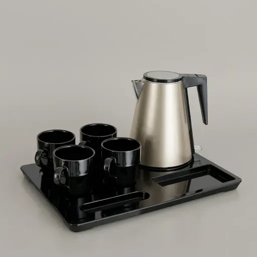 Melamine 3-in-1 Tray Set with Strix Stainless Steel 1.2L Kettle — KTS-1081 — A three-in-one polished melamine welcome tray with an integrated kettle base, two sachet-and-spoon compartments and space for four cups. Rounded corners make it easy to clean, paired with a 1.2L golden double-body Strix stainless steel kettle. A 42x30cm tray finished in black.