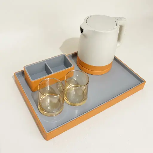 PU Leather Tray Set with Stainless Steel Anti-Scald 0.8L Kettle [1131] — KTS-1131 — An elegant rectangular welcome tray in ABS wrapped with customisable PU leather, with a non-slip pad and a cable cut-out for the kettle. Water-repellent and easy to clean, it presents the kettle, mugs and utensils with a matching tea bag holder, paired with a 0.8L anti-scald kettle. A 39x26cm tray, in grey or orange.