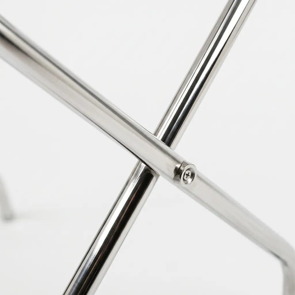 Folding Luggage Rack Backless Stainless Steel — LGR-1024 — A folding backless luggage rack with a sturdy 1-inch stainless steel round-tube frame and four wide 5cm nylon straps to hold heavy bags securely. The flat-and-round tube design looks modern, while plastic foot caps keep it stable and non-slip. Folds flat for storage, measuring 600x425x500mm, in polished steel, brushed steel, titanium gold or black. (image 4)